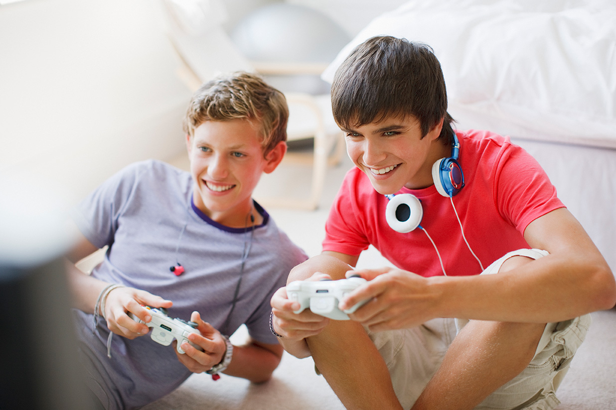 Smiling teenage boys playing video game